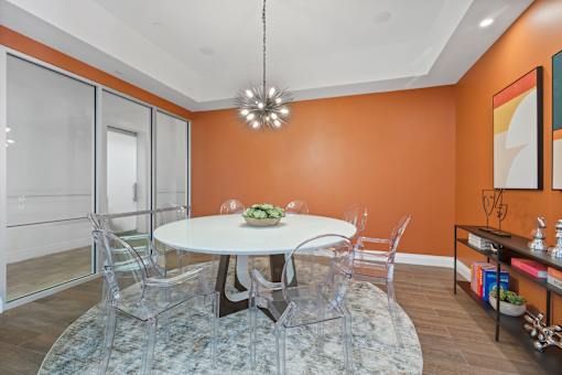 A dining room with a white table and chairs.