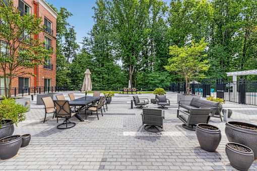 A patio with a table and chairs surrounded by trees.