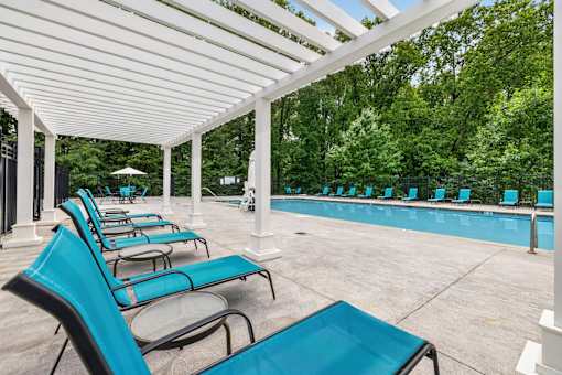 A row of blue chairs are lined up under a white canopy.