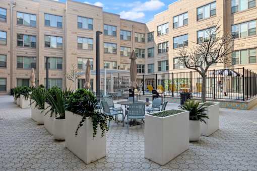 A courtyard with a table surrounded by planters.