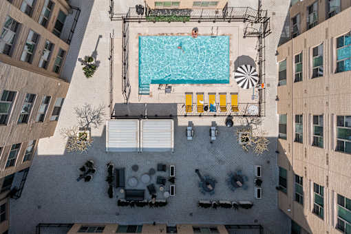 A swimming pool surrounded by yellow chairs and umbrellas.