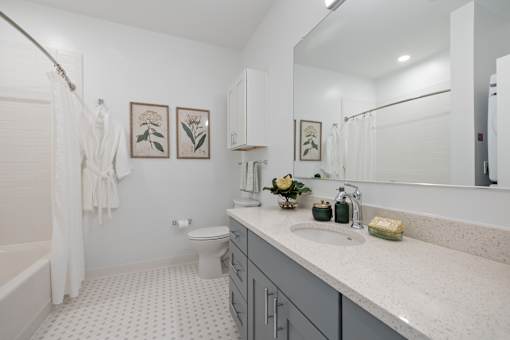 A white bathroom with a toilet, sink, and shower.
