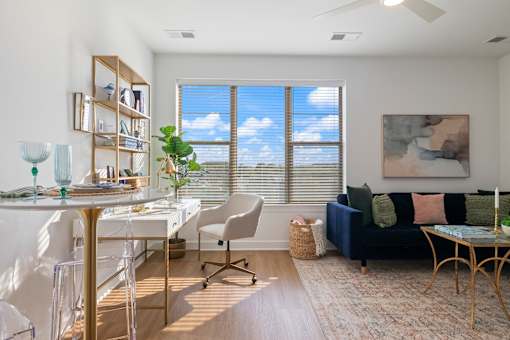 A living room with a couch, chairs, and a dining table.