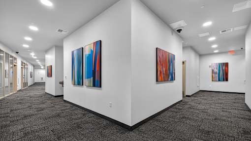 A hallway with a series of paintings on the wall.