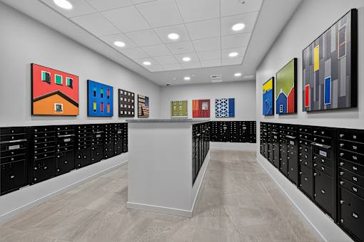 A hallway with a white wall and a row of black lockers on the right.