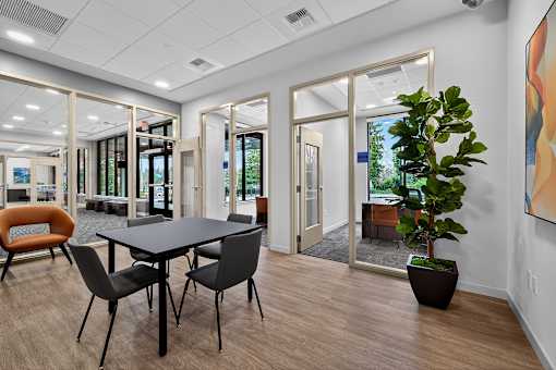 A conference room with a table, chairs, and a potted plant.