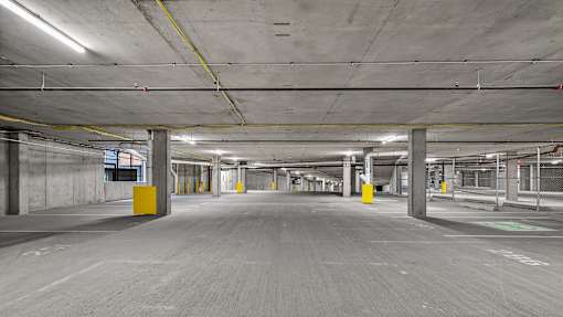 A large, empty parking garage with concrete pillars and floors.