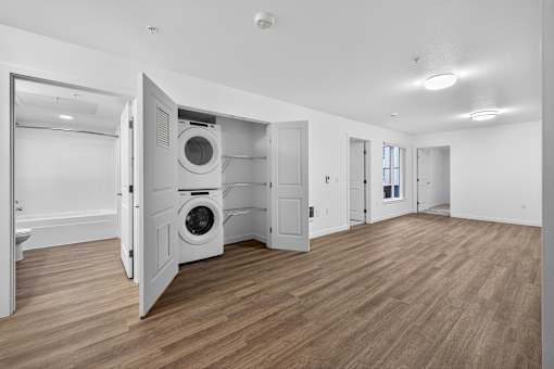 A room with a washing machine in the doorway.