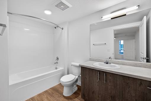 A white bathroom with a toilet, sink, and bathtub.