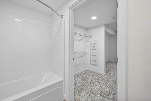 A white bathroom with a walk-in closet.