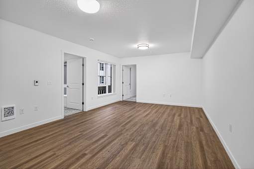 A room with wooden flooring and white walls.