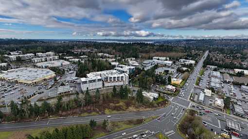 A large, open parking lot sits between two buildings.