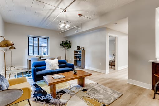 A living room with a blue couch and a wooden coffee table.