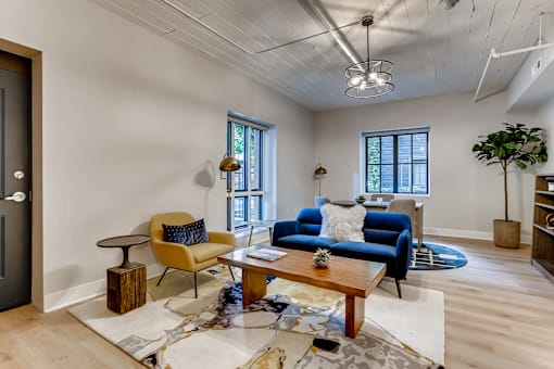A living room with a blue couch and a yellow chair.