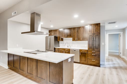 A modern kitchen with wooden cabinets and a white countertop.
