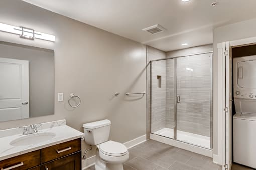 A bathroom with a toilet, sink, and shower.