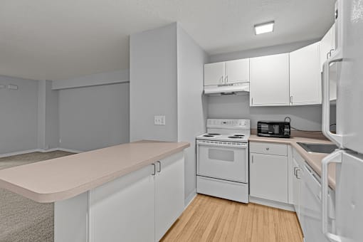 A kitchen with white appliances and cabinets.