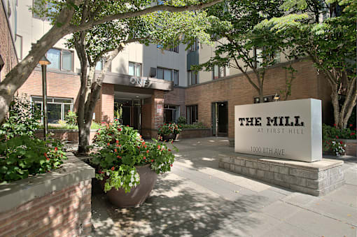 The Mill at First Hill is a modern building with a large entrance and a sign on the front.