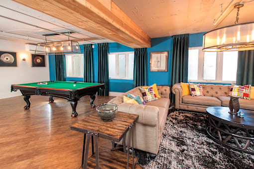 A room with a pool table and a couch.