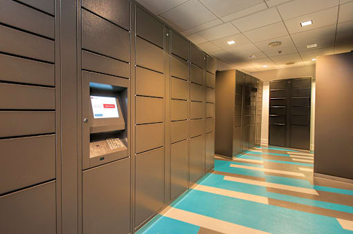 A hallway with a row of ATMs on the wall.