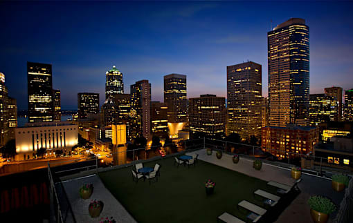 A cityscape at night with a green space in the foreground.