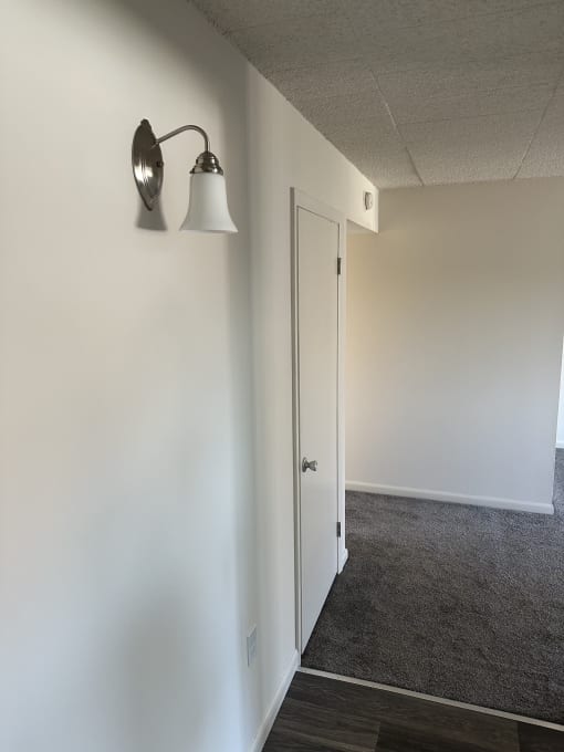 a hallway with a lamp and a door to a closet