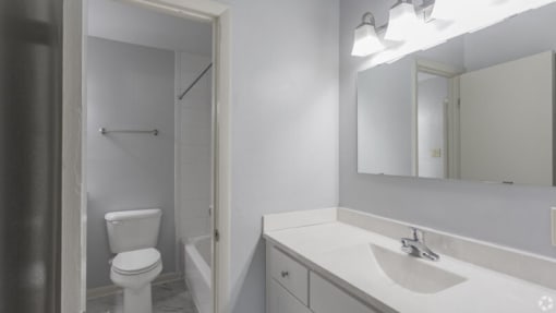 a bathroom with a toilet sink and mirror