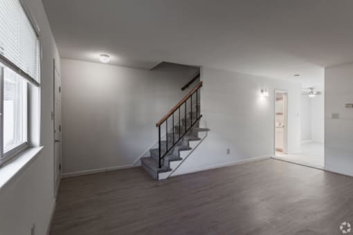 an empty room with a staircase and a window