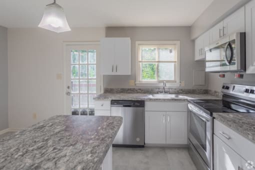 a kitchen with a stove a sink and a microwave