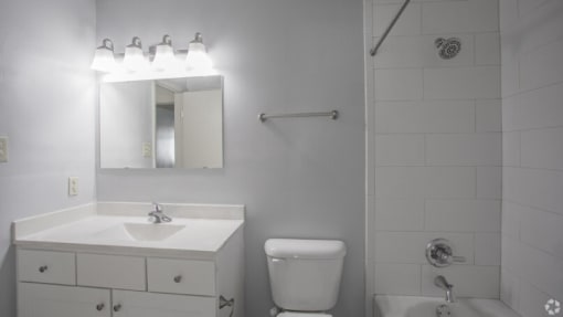 a white bathroom with a white sink and toilet