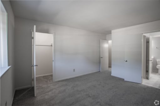 a bedroom with white walls and a carpeted floor