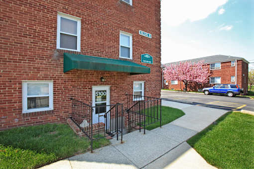 A brick building with a green awning and a sign that says 5100.