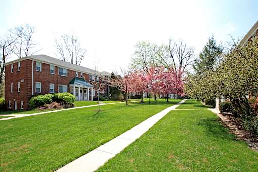 A red brick building with a green lawn in front.
