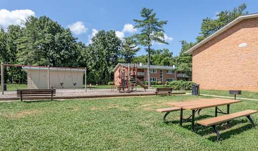 A picnic table sits in the middle of a grassy area.