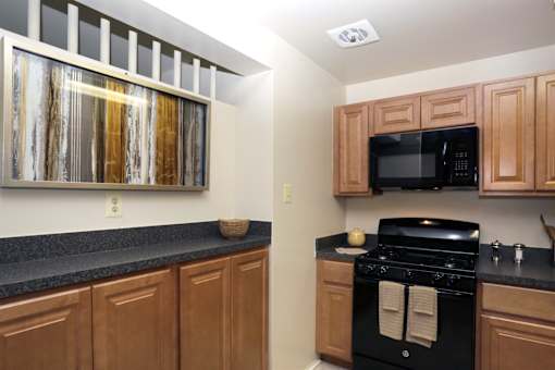 A kitchen with wooden cabinets and a black stove top oven.