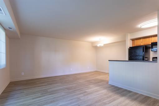 A spacious room with a bar counter and wooden flooring.
