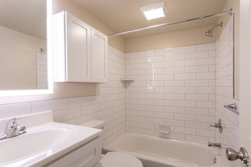 A white bathroom with a sink, toilet, and bathtub.