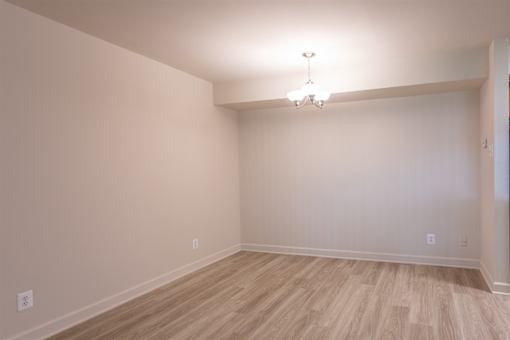 A room with wooden flooring and a chandelier.