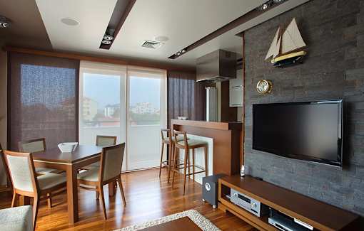 A living room with a television and a dining table.