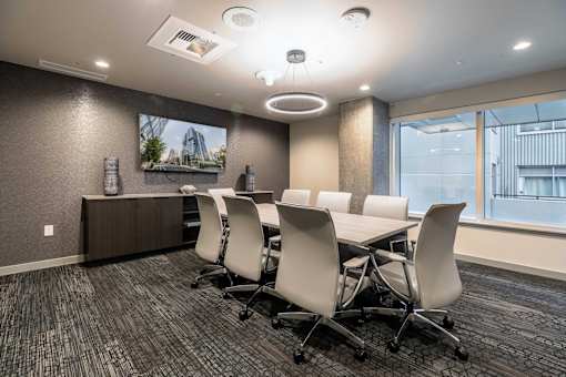 A conference room with a long table and chairs.