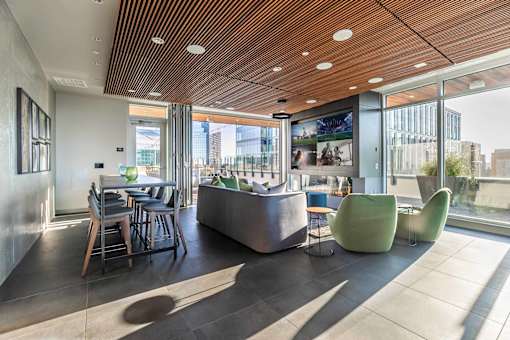 A modern interior space with a wooden ceiling and a large window overlooking a cityscape.