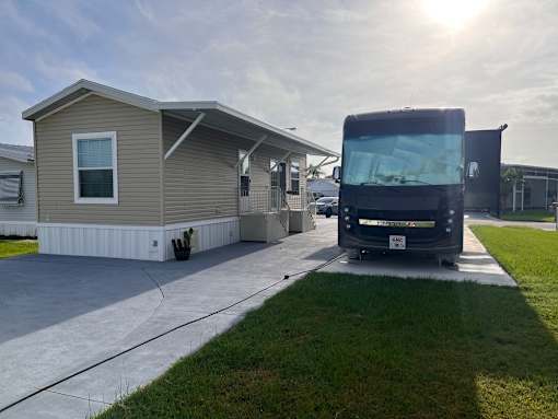 A black bus is parked in front of a house.