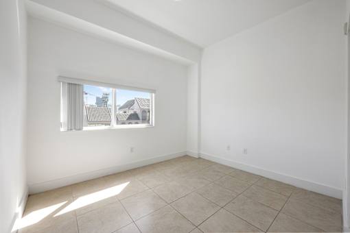 A room with a window and tiled floor.