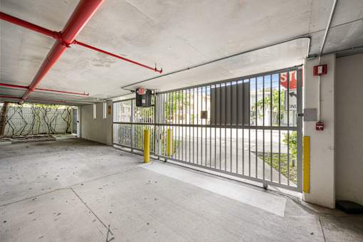 A large, empty parking garage with a red and white striped gate.