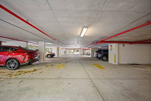 A red car is parked in a parking garage.