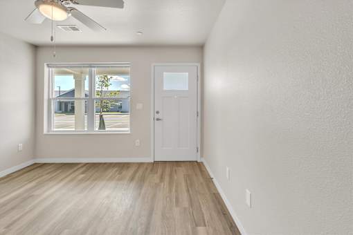 A room with a white door and a window with blinds.