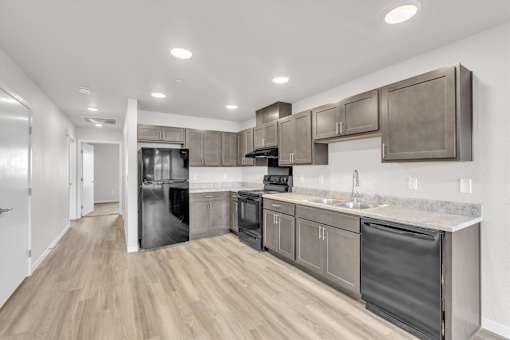A modern kitchen with stainless steel appliances and wooden floors.