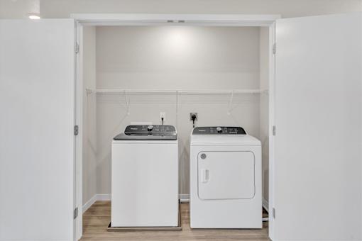A white laundry room with a washer and dryer.