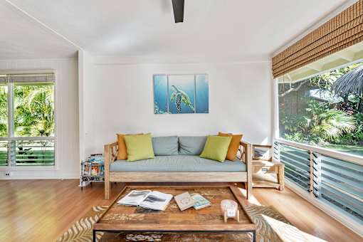 A living room with a couch, a coffee table, and a painting on the wall.