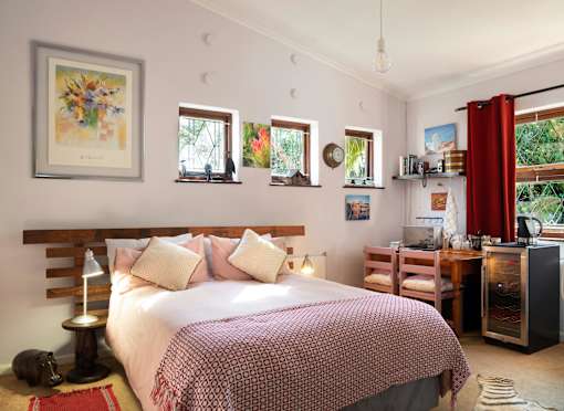A bedroom with a large bed and a painting on the wall.
